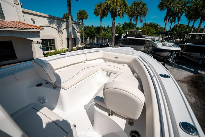 Slide: The Image of 2025 Sea Hunt Ultra 255 SE boat with white seating, docked near palm trees. - 34