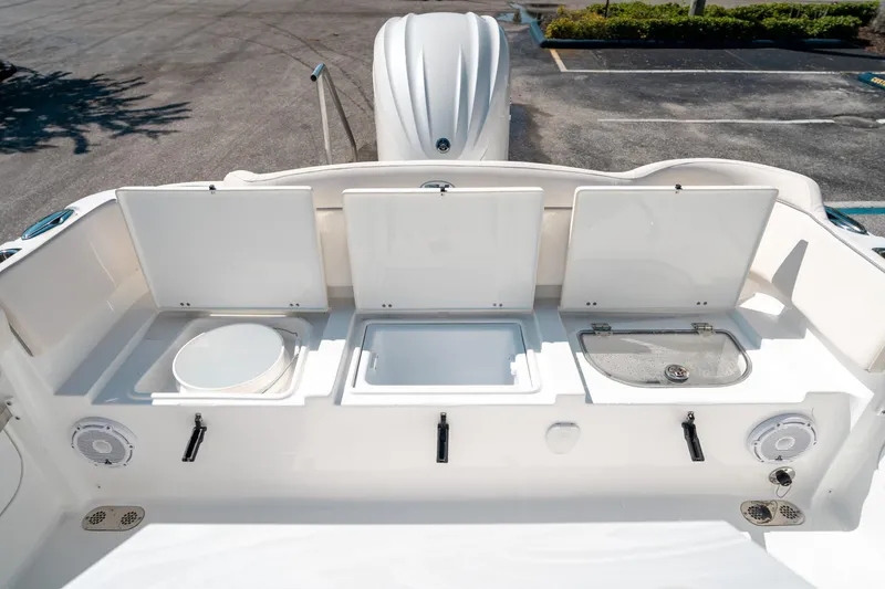 Slide: The Image of 2025 Sea Hunt Ultra 255 SE boat with open storage compartments and seating area. - 14