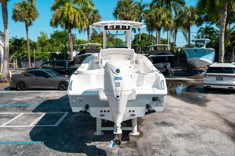 Slide: The Image of 2025 Sea Hunt Ultra 255 SE boat in a sunny parking lot with palm trees. - 3