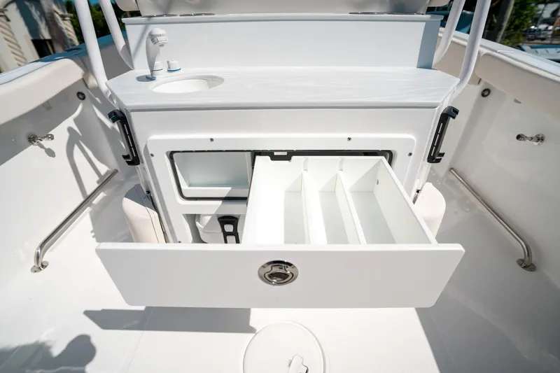 Slide: The Image of 2025 Sea Hunt Ultra 255 SE boat interior with open storage compartment and sink. - 17