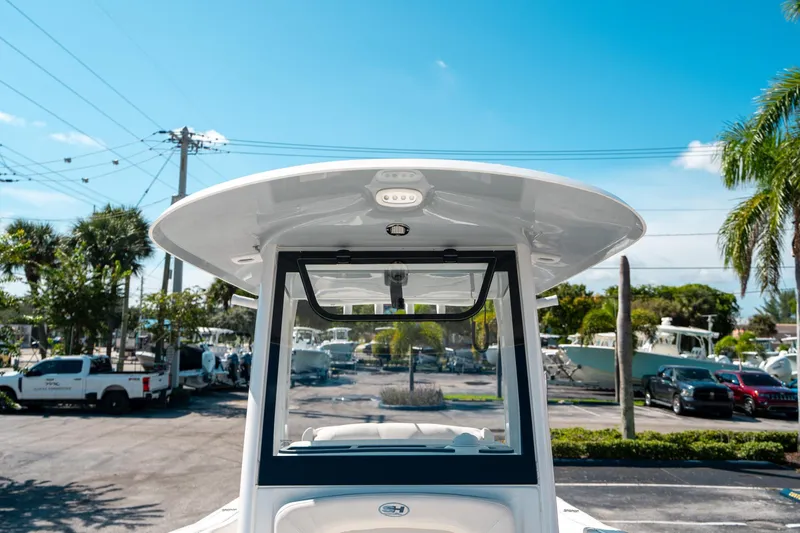 Slide: The Image of 2025 Sea Hunt Ultra 255 SE boat, showcasing helm and T-top under clear blue sky. - 37