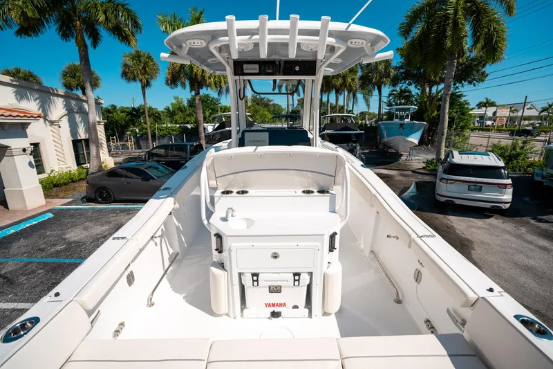Slide: The Image of 2025 Sea Hunt Ultra 255 SE boat in a sunny parking lot with palm trees. - 9