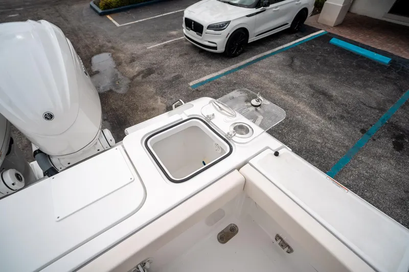 Slide: The Image of 2025 Sea Hunt GAMEFISH 27 CB boat interior with motor and parking lot view. - 15