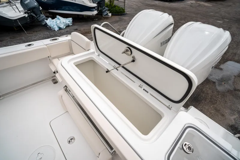 Slide: The Image of 2025 Sea Hunt GAMEFISH 27 CB boat with open storage compartment and dual Yamaha engines. - 14