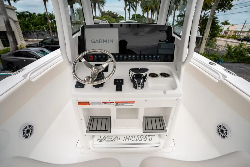 Slide: The Image of 2025 Sea Hunt GAMEFISH 27 CB helm with Garmin display and steering wheel. - 24