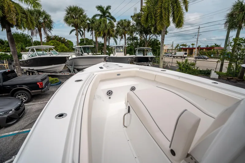 Slide: The Image of 2025 Sea Hunt GAMEFISH 27 CB boat on display with palm trees in the background. - 29