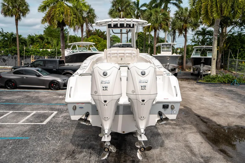Slide: The Image of 2025 Sea Hunt GAMEFISH 27 CB boat with dual Yamaha V6 engines, parked outdoors. - 3