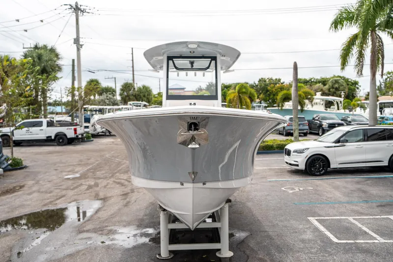 Slide: The Image of 2025 Sea Hunt GAMEFISH 27 CB boat in parking lot, surrounded by cars and palm trees. - 7