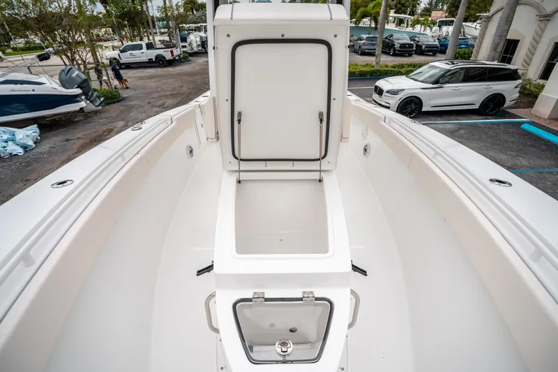 Slide: The Image of 2025 Sea Hunt GAMEFISH 27 CB boat with open storage compartment, parked in a lot. - 33