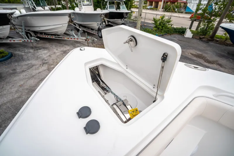 Slide: The Image of 2025 Sea Hunt GAMEFISH 27 CB boat anchor compartment, open lid, showcasing storage space. - 34