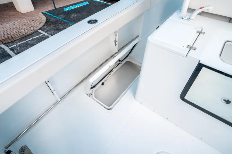 Slide: The Image of 2025 Sea Hunt Gamefish 30 FS boat interior with storage compartment and sink. - 20