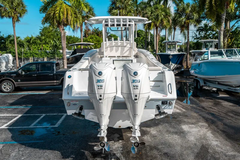 Slide: The Image of 2025 Sea Hunt Gamefish 30 FS boat with dual Yamaha 300 V6 engines, parked outdoors. - 3