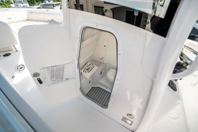Slide: The Image of 2025 Sea Hunt Gamefish 30 FS boat interior with open door revealing compact bathroom. - 30