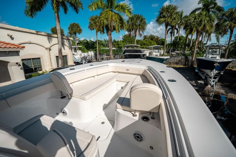 Slide: The Image of 2025 Sea Hunt Gamefish 30 FS boat with spacious seating, surrounded by palm trees. - 33