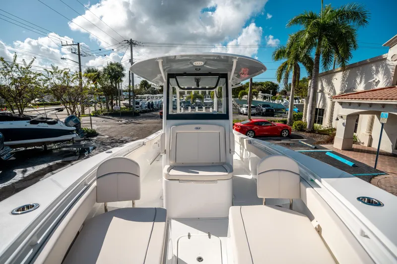 Slide: The Image of 2025 Sea Hunt Gamefish 30 FS boat interior with seating, parked near palm trees. - 35