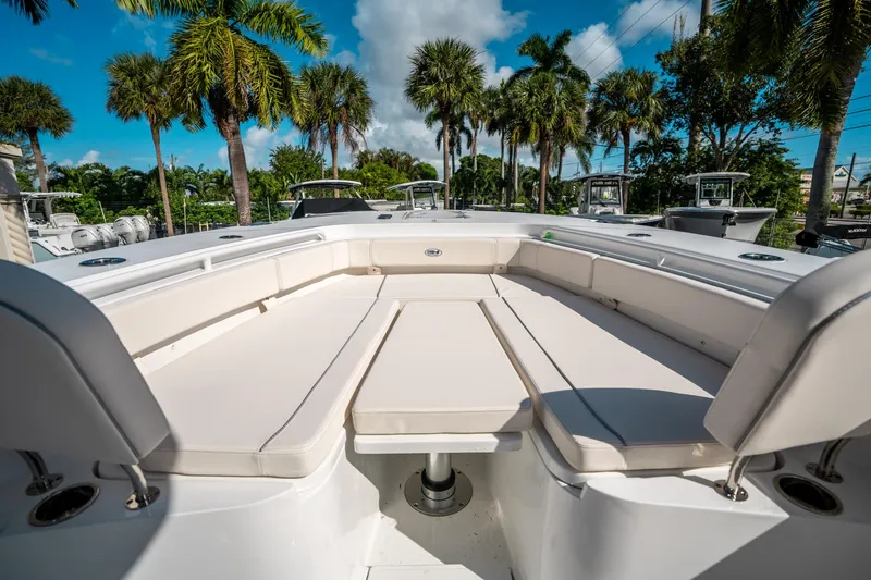 Slide: The Image of 2025 Sea Hunt Gamefish 30 FS boat interior with cushioned seating, surrounded by palm trees. - 36