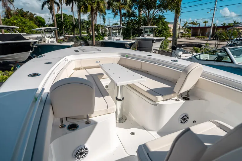 Slide: The Image of 2025 Sea Hunt Gamefish 30 FS boat interior with seating and table, surrounded by palm trees. - 37