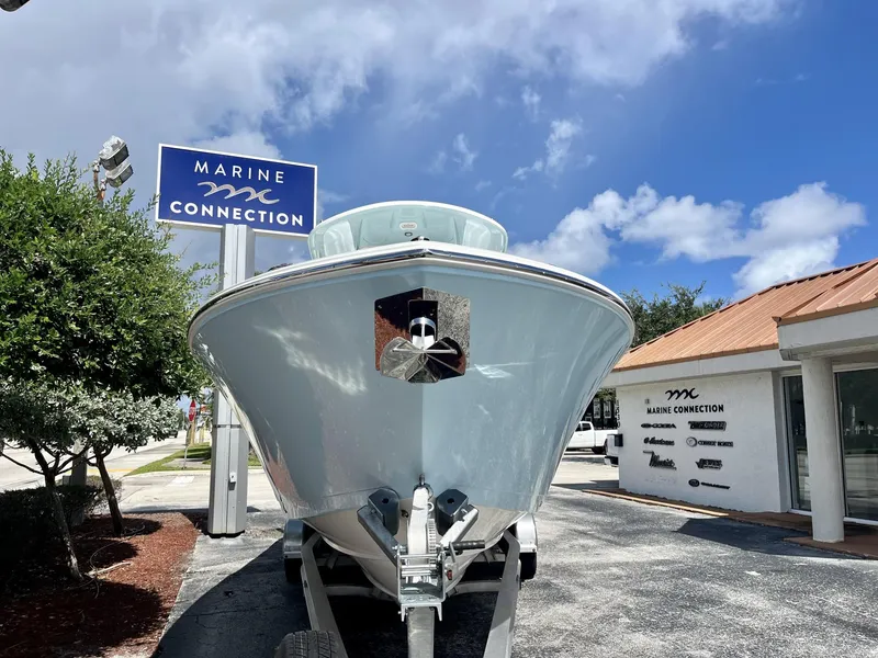 Slide: The Image of 2025 Cobia 285 CC boat at Marine Connection dealership under blue sky. - 3