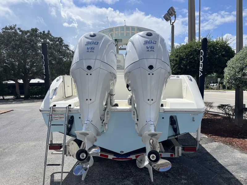 Slide: The Image of 2025 Cobia 285 CC boat with dual 300 V6 engines, parked outdoors. - 5
