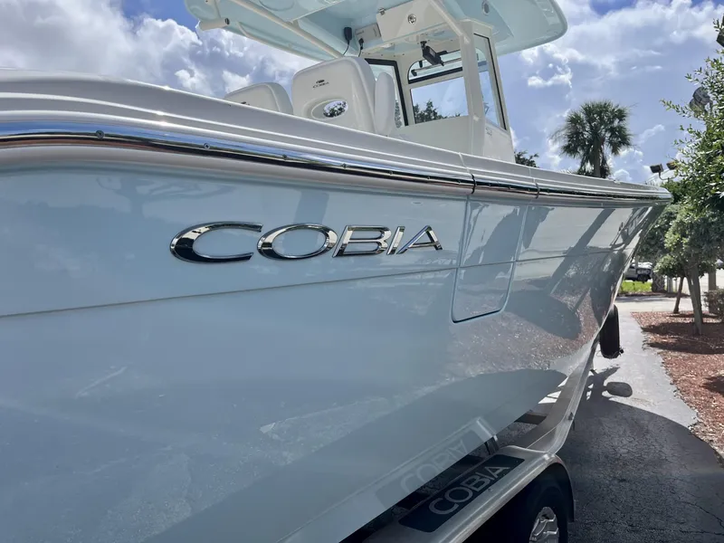 Slide: The Image of 2025 Cobia 285 CC boat with sleek design under a sunny sky. - 7