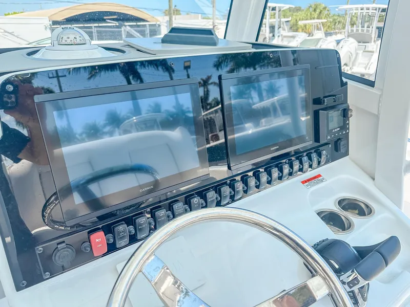 Slide: The Image of 2025 Sea Hunt Ultra 275 SE dashboard with dual Garmin displays and steering wheel. - 17