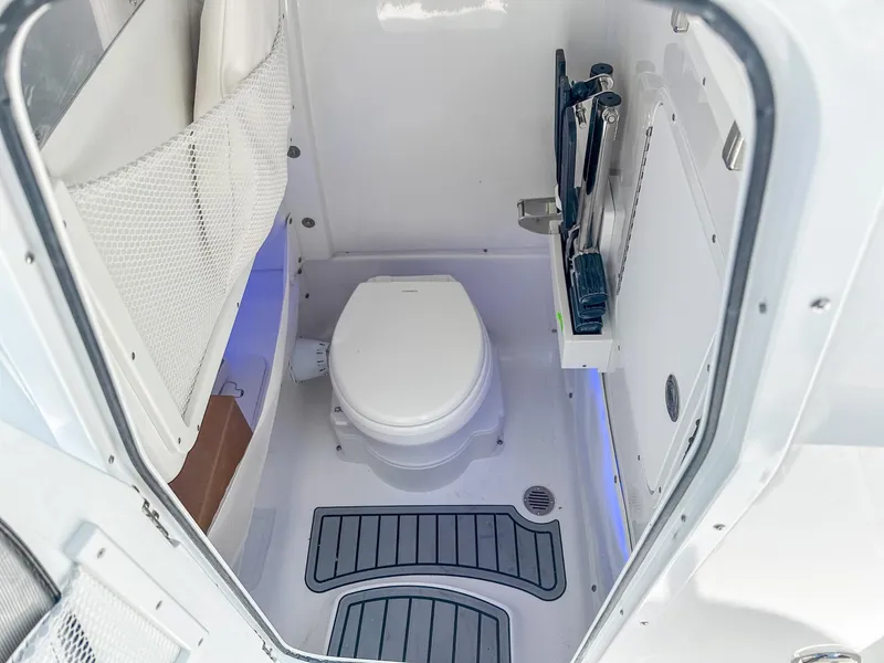 Slide: The Image of 2025 Sea Hunt Ultra 275 SE boat interior bathroom with toilet and storage. - 20