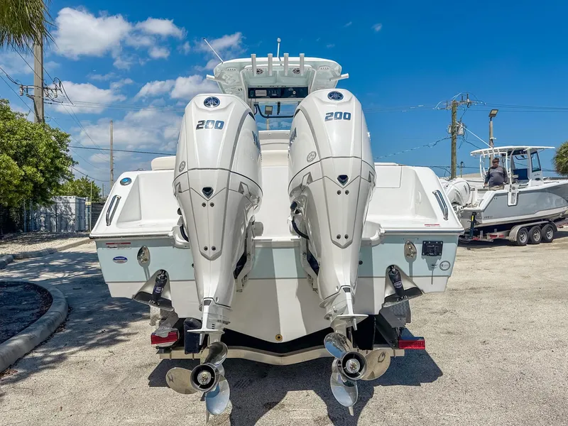 Slide: The Image of 2025 Sea Hunt Ultra 275 SE boat with dual 200 horsepower engines, parked outdoors. - 5
