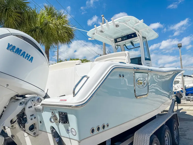 Slide: The Image of 2025 Sea Hunt Ultra 275 SE boat with Yamaha engine, parked on a trailer under a clear sky. - 6
