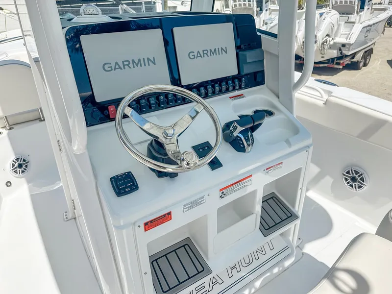 Slide: The Image of 2025 Sea Hunt Ultra 275 SE boat dashboard with dual Garmin displays and steering wheel. - 15