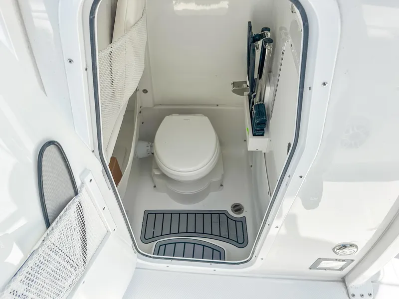 Slide: The Image of 2025 Sea Hunt Ultra 275 SE boat interior bathroom with toilet and storage. - 19