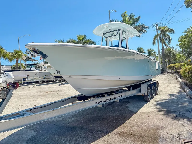 Slide: The Image of 2025 Sea Hunt Ultra 275 SE boat on trailer, parked outdoors under clear blue sky. - 4