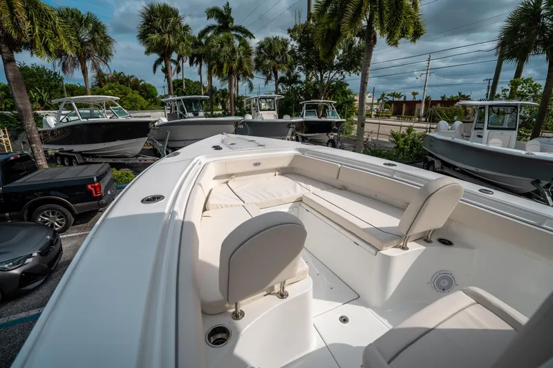 Slide: The Image of 2025 Sea Hunt Gamefish 27 FS boat, spacious seating, parked among palm trees and other boats. - 33