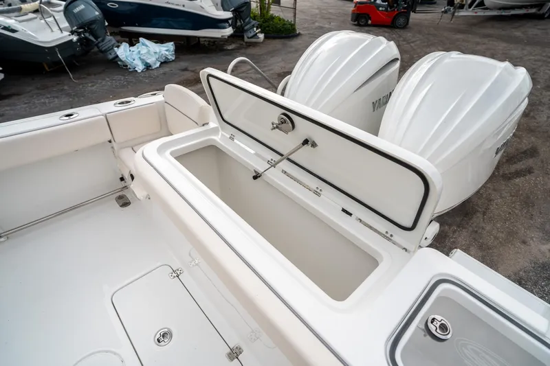Slide: The Image of 2025 Sea Hunt Gamefish 27 FS boat with open storage compartment and dual Yamaha engines. - 13