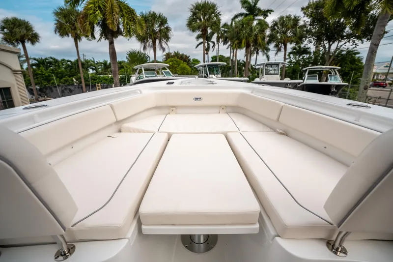Slide: The Image of 2025 Sea Hunt Gamefish 27 FS boat with spacious seating and lush palm trees in the background. - 36