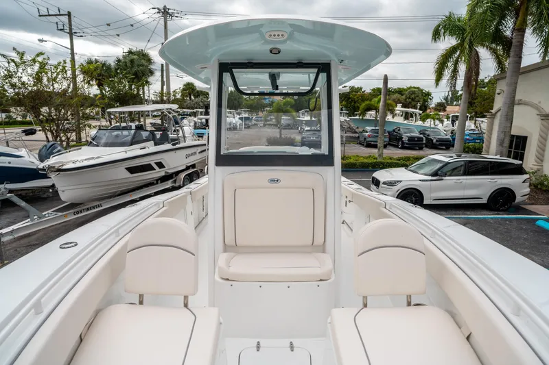 Slide: The Image of 2025 Sea Hunt Gamefish 27 FS boat interior with seating, parked in a marina. - 38