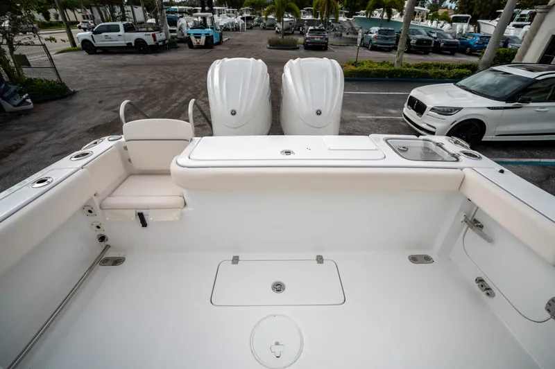 Slide: The Image of 2025 Sea Hunt Gamefish 27 FS boat interior with dual engines, parked in a marina. - 10