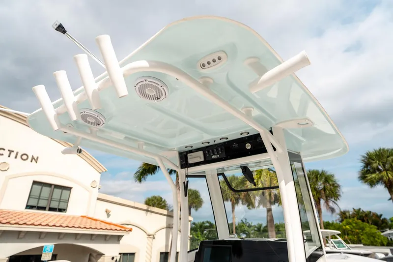 Slide: The Image of 2025 Sea Hunt Gamefish 27 FS boat with T-top and rod holders, under a cloudy sky. - 22