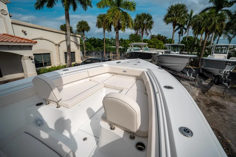 Slide: The Image of 2025 Sea Hunt Gamefish 27 FS boat with white seating, parked near palm trees. - 34