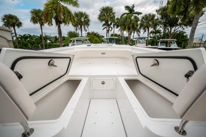 Slide: The Image of 2025 Sea Hunt Gamefish 27 FS boat with open storage compartments, surrounded by palm trees. - 40