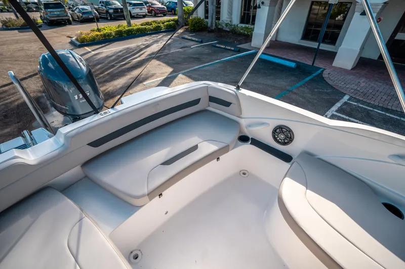 Slide: The Image of 2025 Hurricane SunDeck Sport 185 OB boat interior with seating and motor in parking lot. - 12