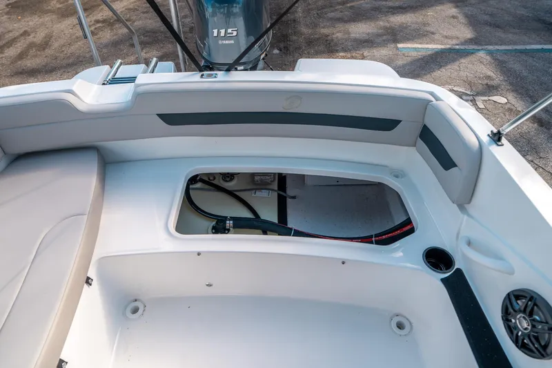 Slide: The Image of 2025 Hurricane SunDeck Sport 185 OB boat interior with open storage compartment and Yamaha 115 engine. - 13