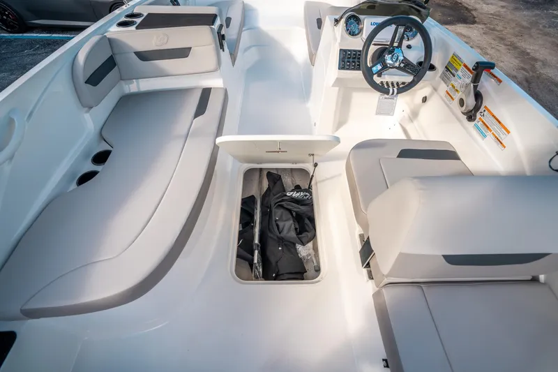 Slide: The Image of 2025 Hurricane SunDeck Sport 185 OB interior with open storage compartment and seating. - 19