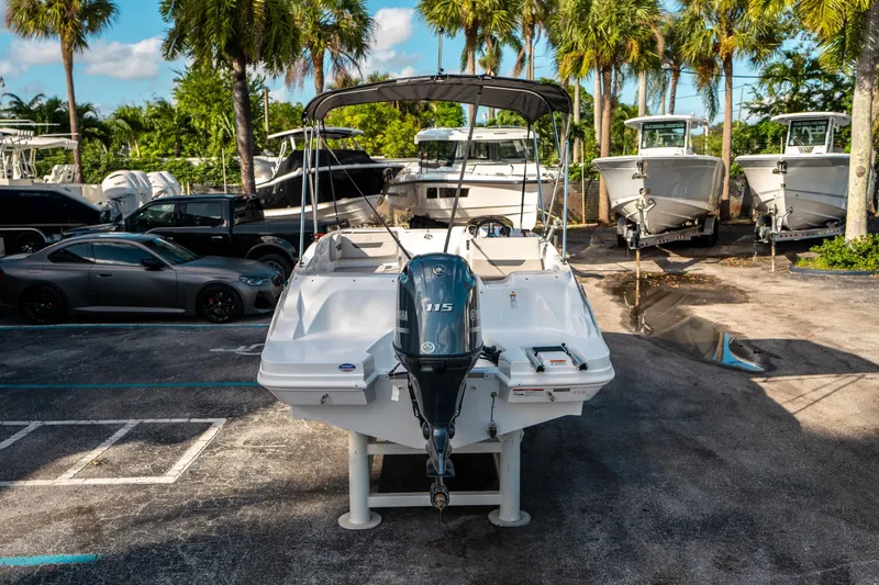 Slide: The Image of 2025 Hurricane SunDeck Sport 185 OB boat in a marina with palm trees. - 3