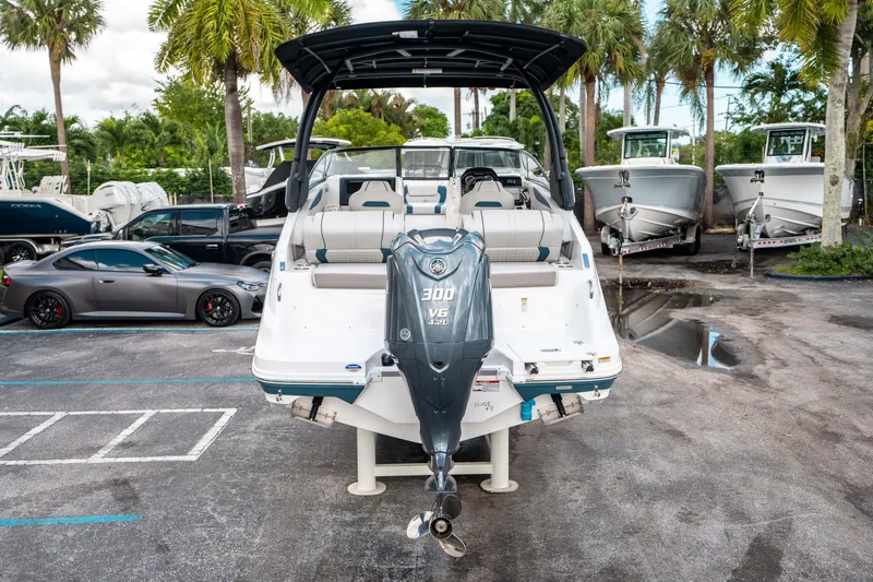 Slide: The Image of 2025 Hurricane SunDeck 2600 OB boat with 300 HP engine, parked near palm trees. - 3