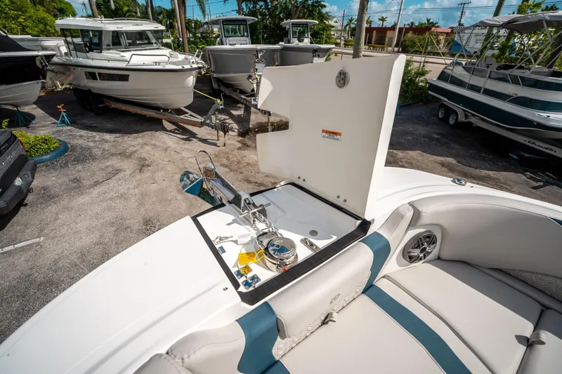 Slide: The Image of 2025 Hurricane SunDeck 2600 OB boat interior with open storage compartment, docked in a marina. - 32