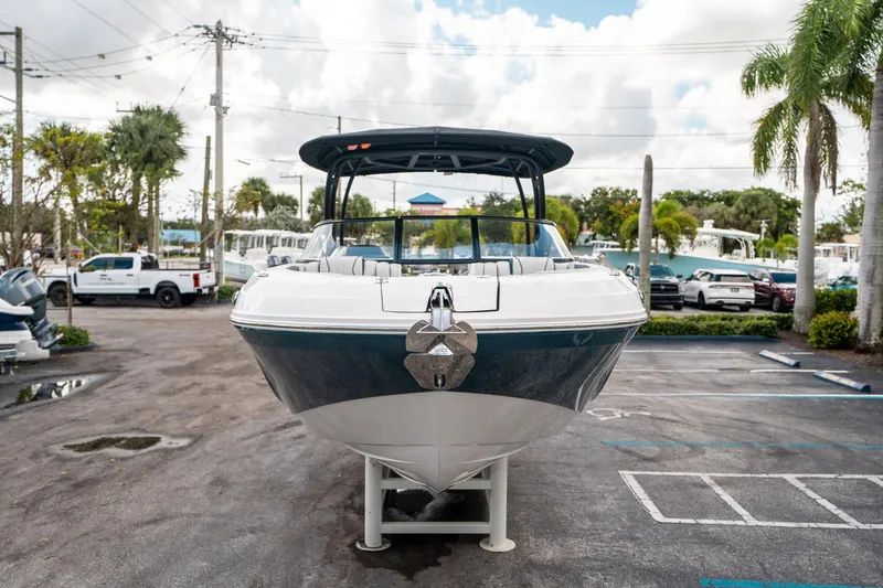 Slide: The Image of 2025 Hurricane SunDeck 2600 OB boat displayed in a parking lot with palm trees. - 7