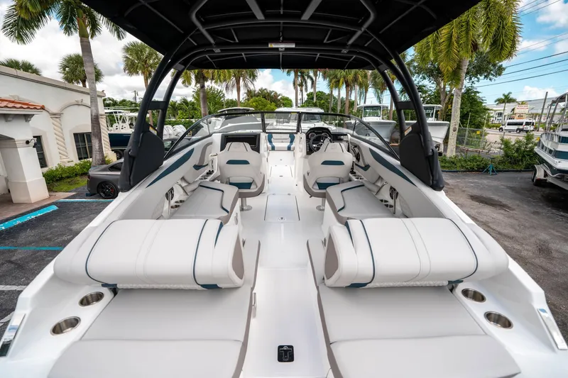 Slide: The Image of 2025 Hurricane SunDeck 2600 OB boat interior with white seating and canopy, parked outdoors. - 9