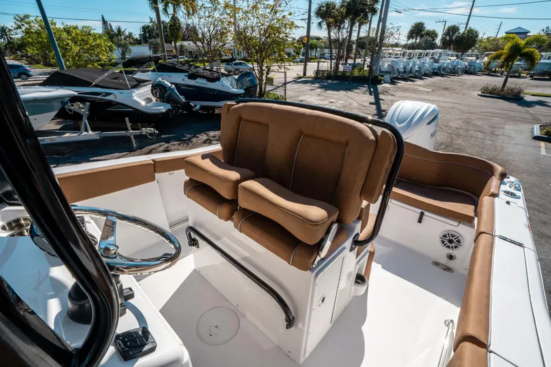 Slide: The Image of 2025 Sea Hunt Ultra 255 SE boat interior with tan seating and steering wheel. - 26