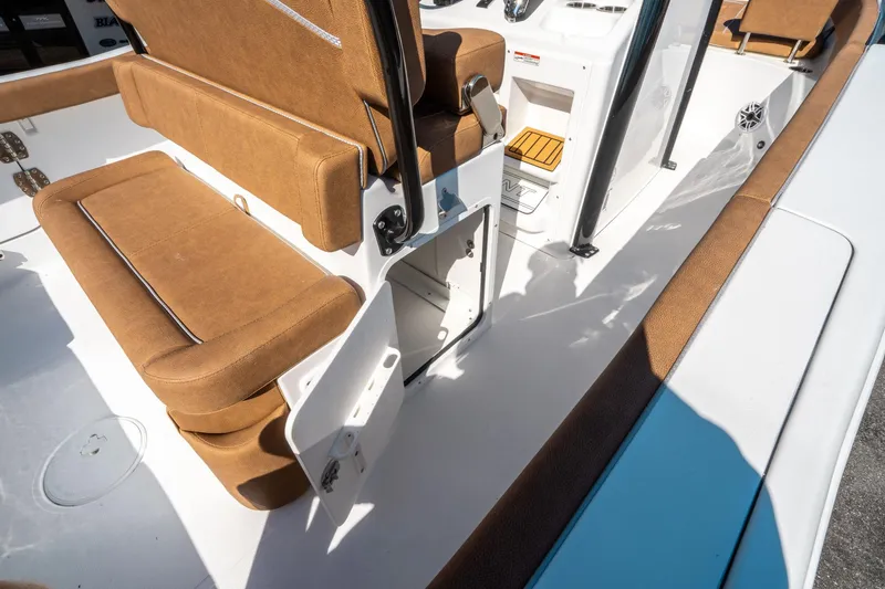 Slide: The Image of 2025 Sea Hunt Ultra 255 SE boat interior with brown seating and storage compartment. - 19