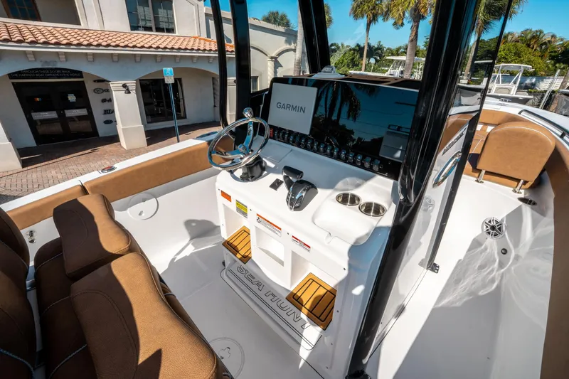 Slide: The Image of 2025 Sea Hunt Ultra 255 SE boat interior with Garmin navigation system and brown seating. - 25